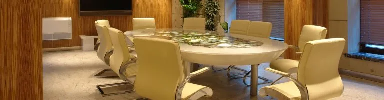 White conference table and white office chairs inside a conference room.