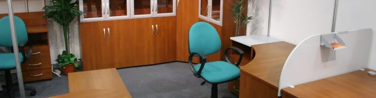 Inside of an office area, including desk chair, desk, and cabinets.