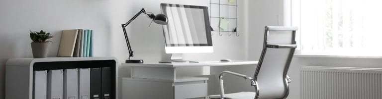 Interior of office featuring a desk, chair, and computer