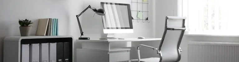 Interior of office featuring a desk, chair, and computer
