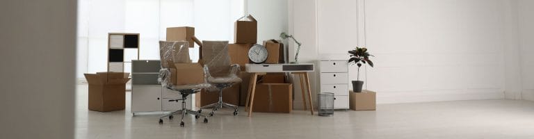 Office furniture, including chairs, desks, cabinets, being staged for move in.