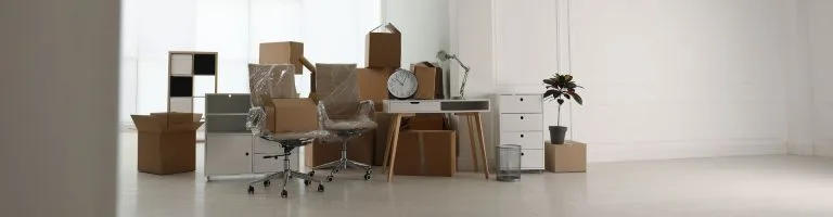 Office furniture, including chairs, desks, cabinets, being staged for move in.