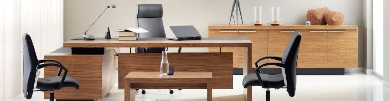 Inside of an office with a desk and an old chair, which needs to be replaced.