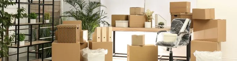 Inside of a commercial office with boxes full of things needing to be unpacked.